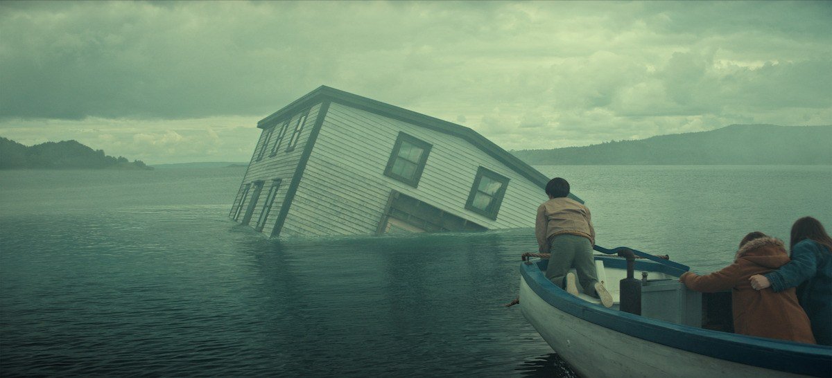 Casa afundando no mar em cena de Profundezas, série da Netflix com Josh Hartnett